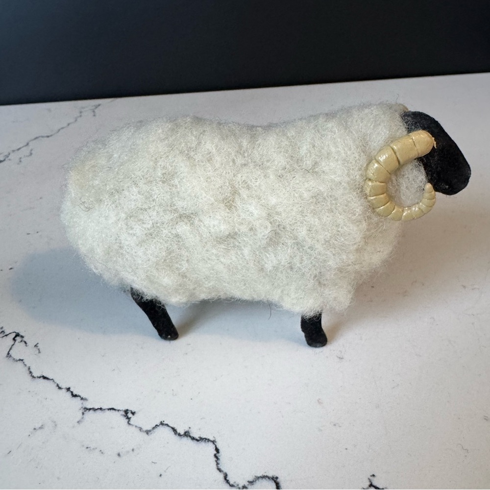 Handcrafted wool sheep figurine with black legs and curved horns